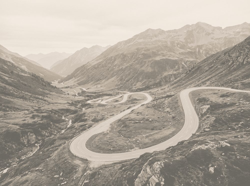 Duotone photograph of a winding alpine highway for BMW